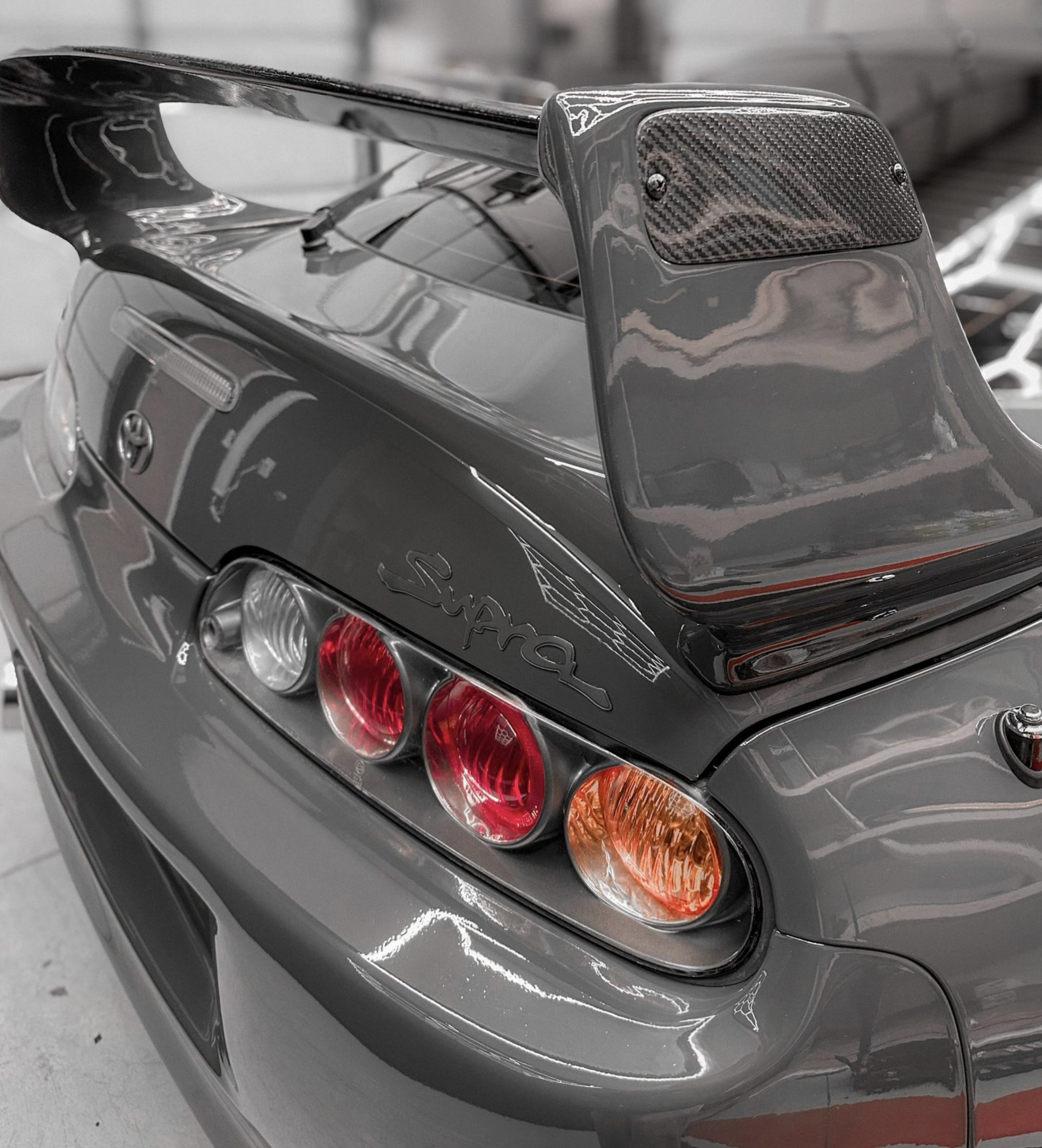 A toyota supra with a gloss grey vehicle wrap.
